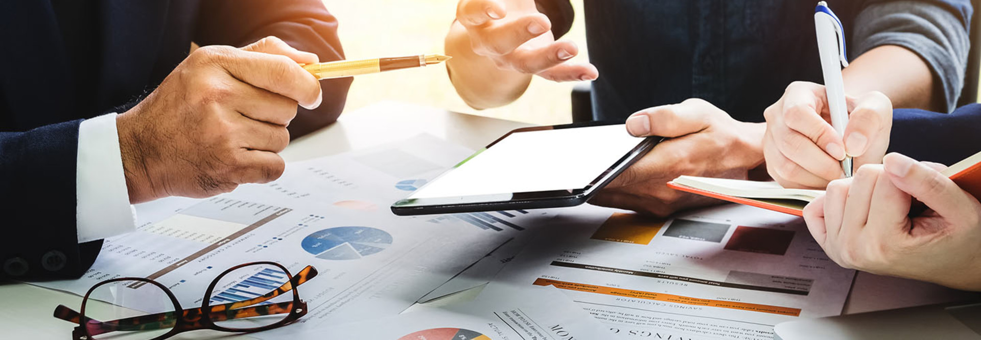Business people using pen,tablet,notebook are planning a marketing plan to improve the quality of their sales in the future.
