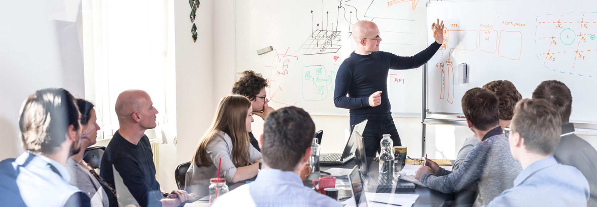 A group of developers in a training session with a whiteboard