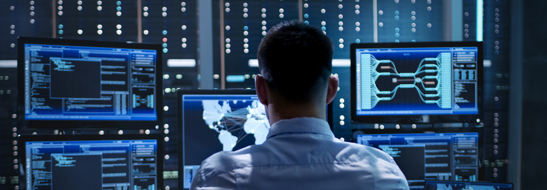 Federal cybersecurity worker sitting behind many monitors 