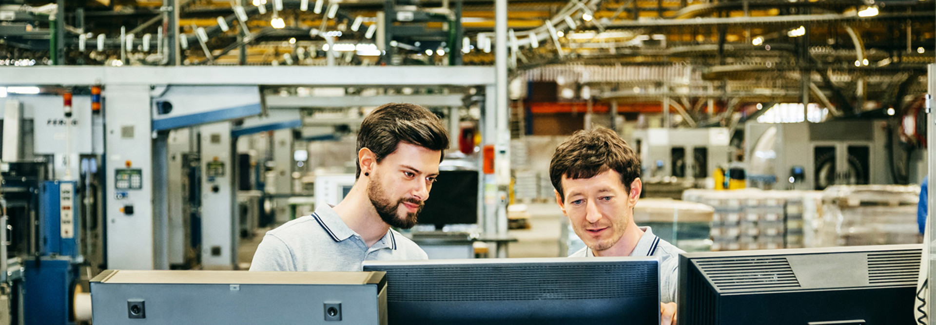 Men reviewing a supply chain at a technology plant 