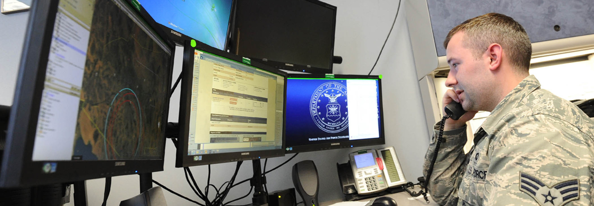 Senior Airman Dakota Powers, Air Force Rescue Coordination Controller, monitors computer screens while taking a phone call April 5 at the 601st Air Operations Center. The facility is staffed 24/7 to respond to, and coordinate rescue operations.
