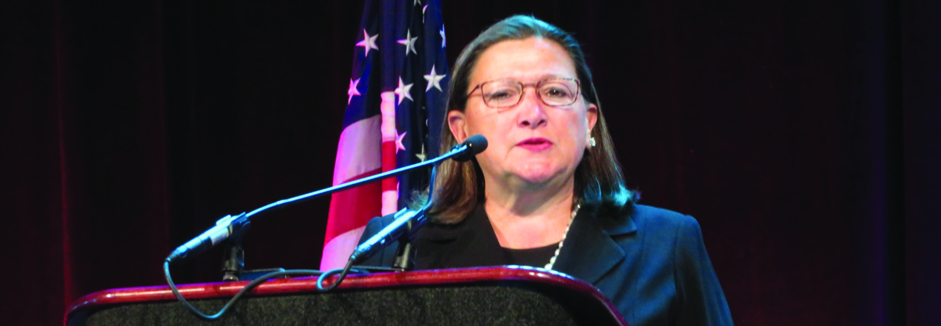 Woman with glasses behind podium