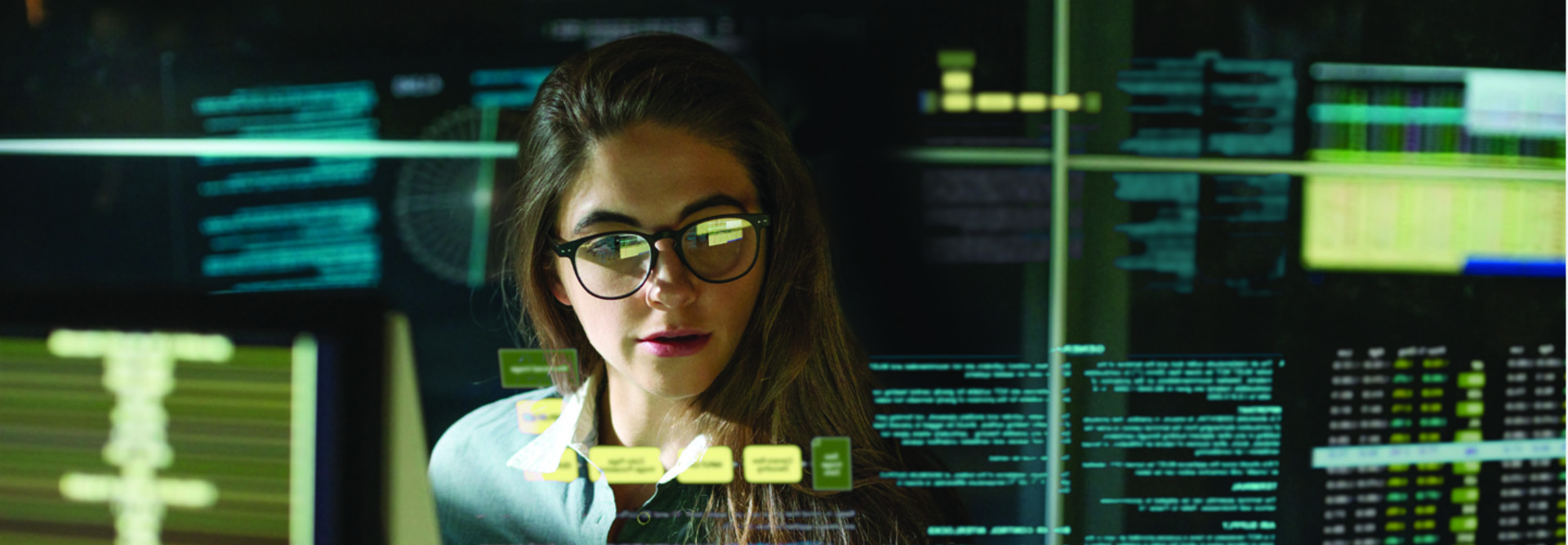 woman behind monitor with data floating near her