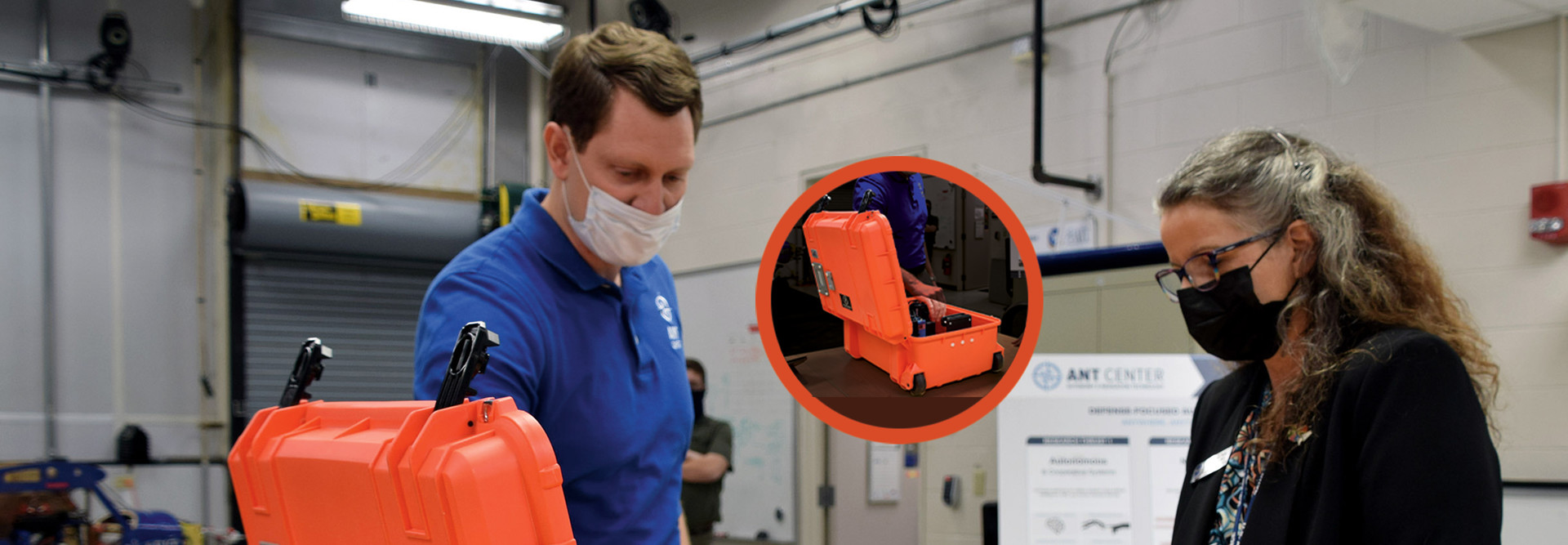 Man and woman in masks looking at orange box