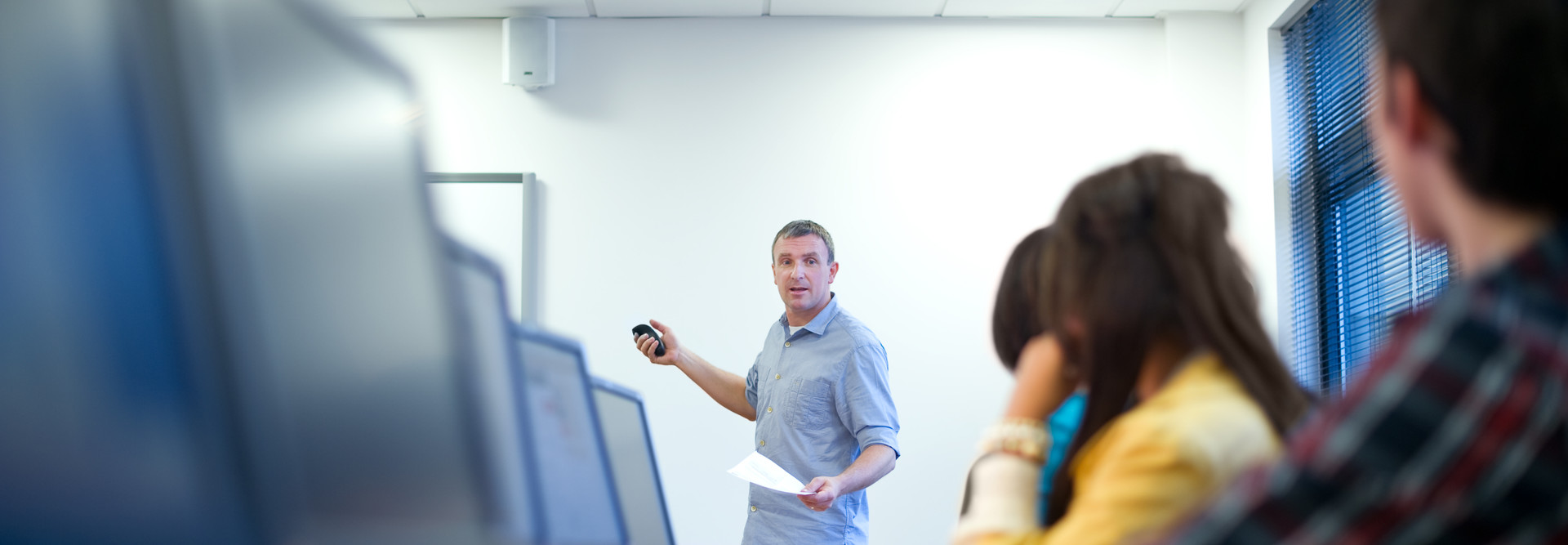 man teaching class sitting in front of computers