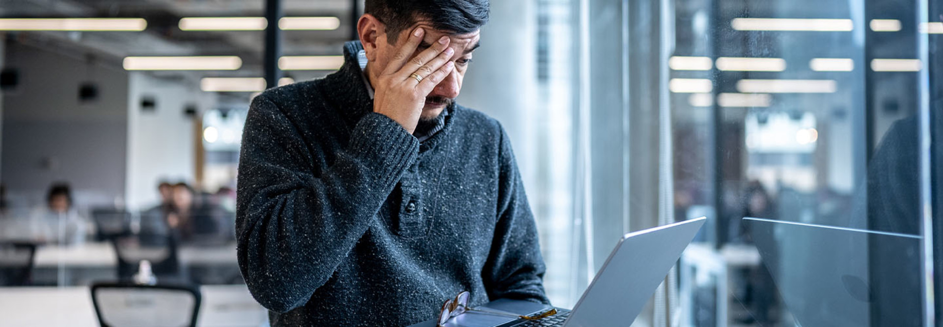 Worried man looking at his laptop in the office