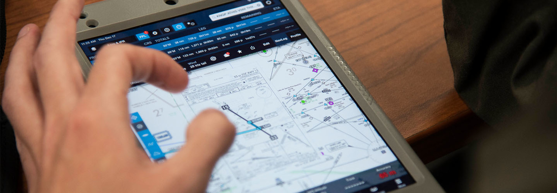Naval aviator student planning a virtual training flight on a tablet.