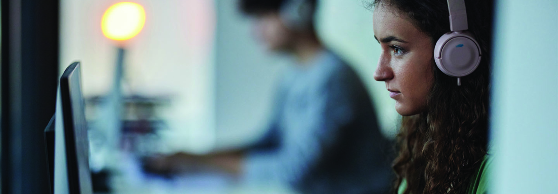 Woman at a monitor with headphones