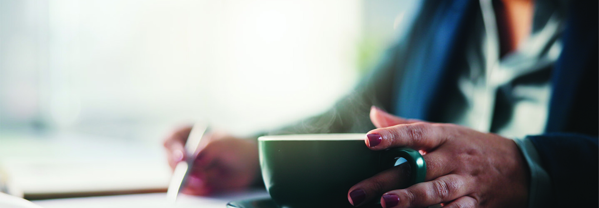 Lady writing with cup of coffee