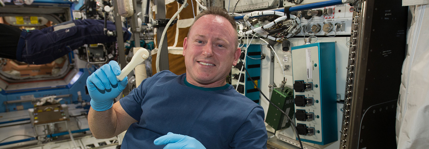 International Space Station Expedition 42 Commander Barry "Butch" Wilmore shows off a ratchet wrench made with a 3D printer on the station.