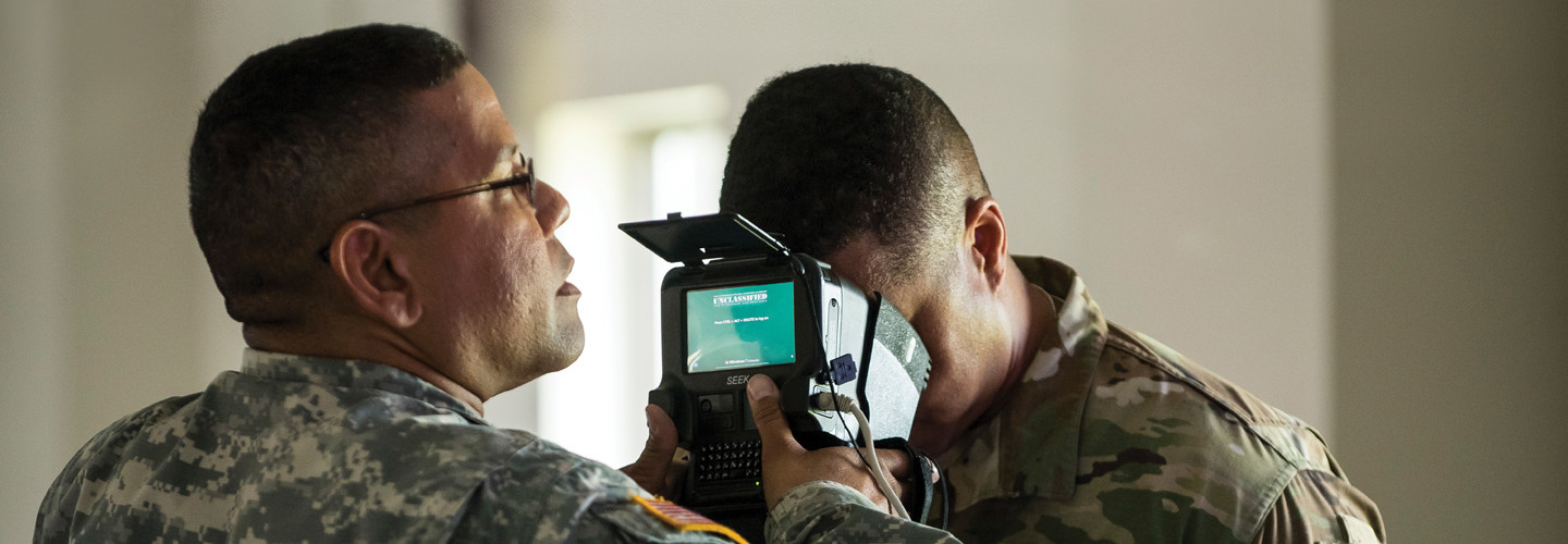 U.S. Army Reservists learn how to use iris scans to identify personnel during a training exercise.