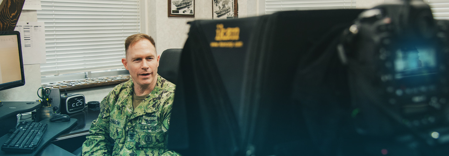 man in camo uniform talking to a TV camera