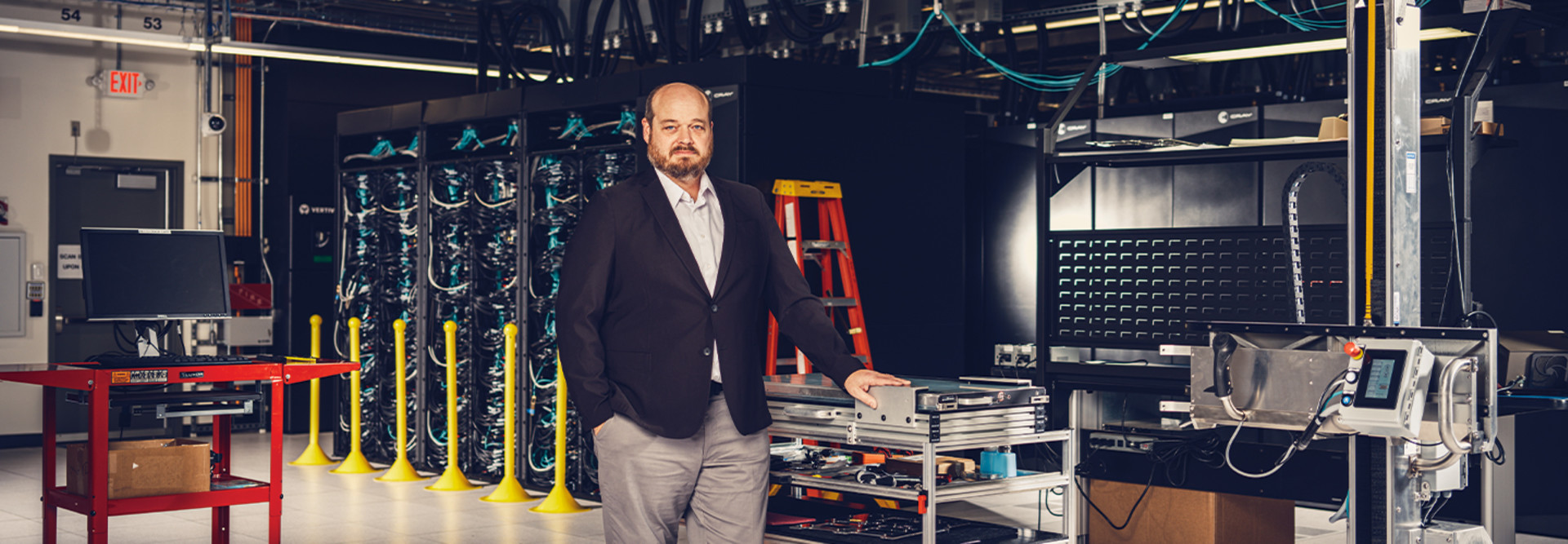 man in jacket standing by supercomputer