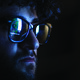 Computer code reflected on the glasses on a man's face