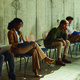 People waiting in chairs against wall