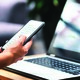 Person using phone and laptop