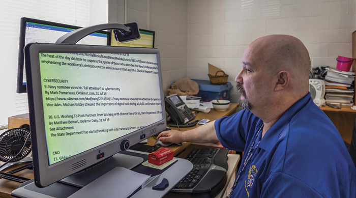 John Tebo, who works at the  Naval Undersea Warfare Center, uses a special device to help him read text and do his job.