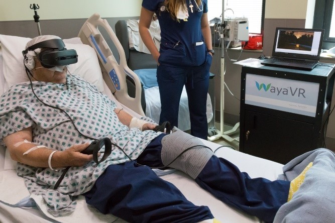 Caitlin Rawlins, BSN, RN, assists a Veteran with using VR therapy following a total knee arthroplasty