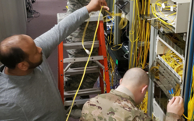 Senior Airman Kyle Courtney and Staff Sgt. Nicholas Prindiville of the 55th Communications Squadron, and Felix Rodriguez, AT&T-General Dynamics IT contractor, work to patch network connectivity around flood-damaged buildings to restore mission capabilities at Offutt Air Force 