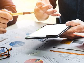 Business people using pen,tablet,notebook are planning a marketing plan to improve the quality of their sales in the future.