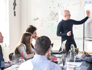 A group of developers in a training session with a whiteboard