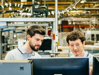 Men reviewing a supply chain at a technology plant 