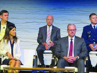 Two rows of people, three men at the top, one man, one woman and two men at the bottom, all in business wear