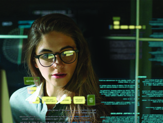 woman behind monitor with data floating near her