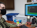 Yeoman 2nd Class Niko Counce, assigned to Commander, Fleet Activities Okinawa, verifies Sailor's information using the Navy Standard Integrated Personnel System on Kadena Air Base in Okinawa, Japan, Aug. 5, 2020.