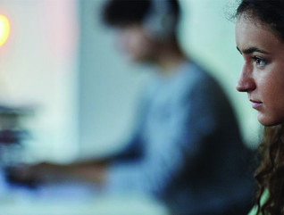 Woman at a monitor with headphones