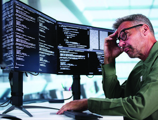 Man looking at coding on computer