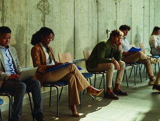People waiting in chairs against wall