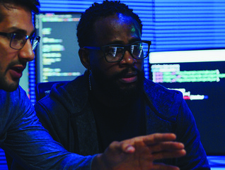 two male coworkers working in tech office