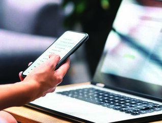Person using phone and laptop
