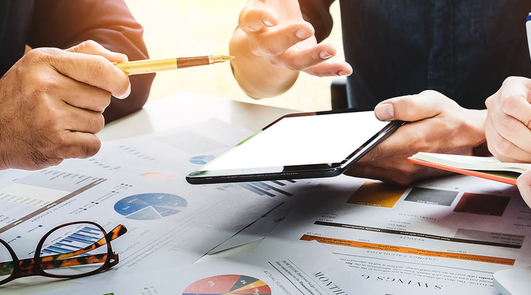 Business people using pen,tablet,notebook are planning a marketing plan to improve the quality of their sales in the future.