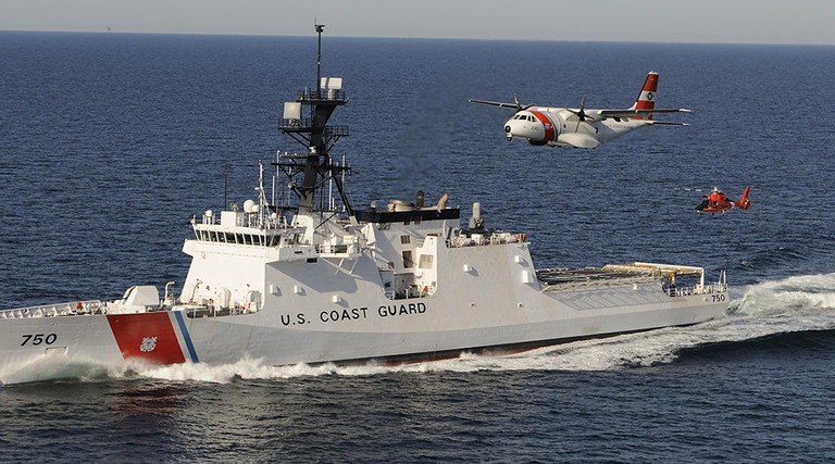 The U. S. Coast Guard's first national security cutter, the Bertholf, operating in concert an HC-144 maritime patrol aircraft and an MH-65 helicopter.