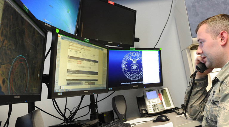 Senior Airman Dakota Powers, Air Force Rescue Coordination Controller, monitors computer screens while taking a phone call April 5 at the 601st Air Operations Center. The facility is staffed 24/7 to respond to, and coordinate rescue operations.