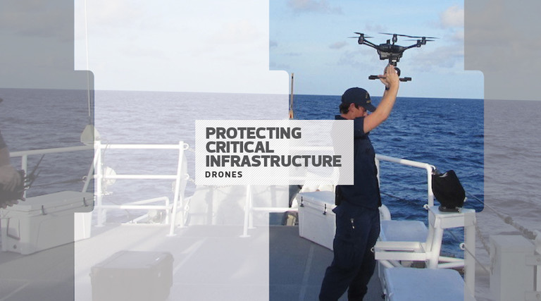 man in military uniform holding a drone over his head on a boat