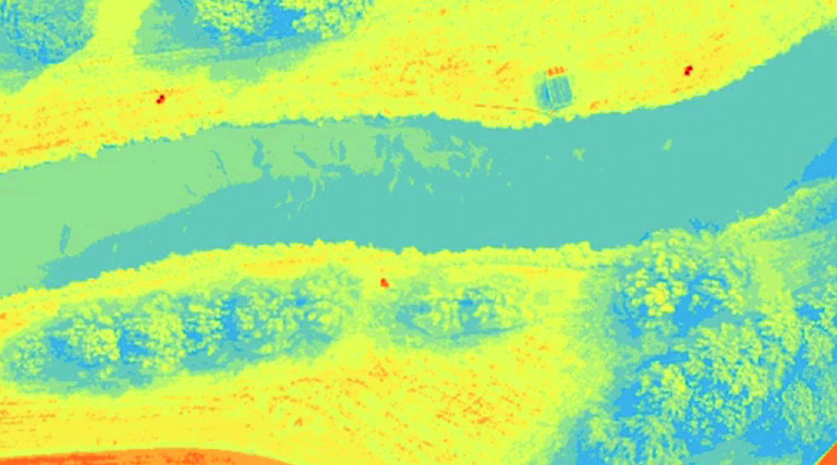 aerial imagery of a narrow pond tinted yellow and blue