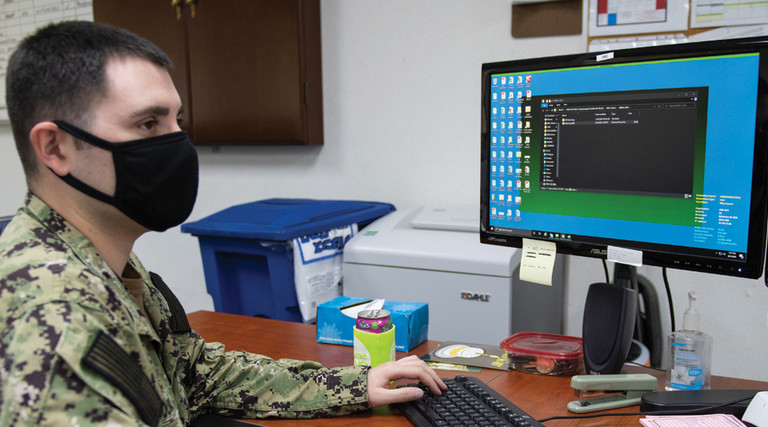 Yeoman 2nd Class Niko Counce, assigned to Commander, Fleet Activities Okinawa, verifies Sailor's information using the Navy Standard Integrated Personnel System on Kadena Air Base in Okinawa, Japan, Aug. 5, 2020.