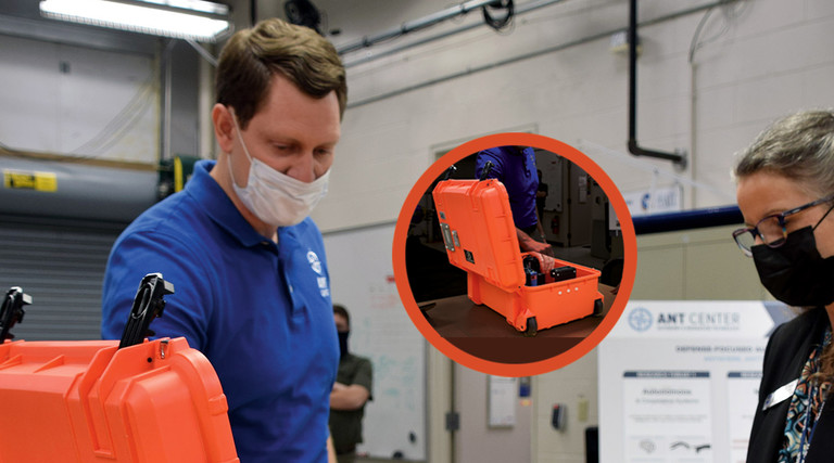 Man and woman in masks looking at orange box