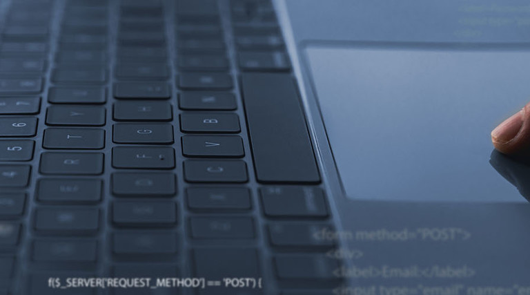 A software developer codes on a laptop