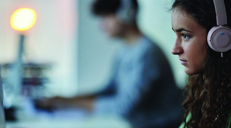 Woman at a monitor with headphones