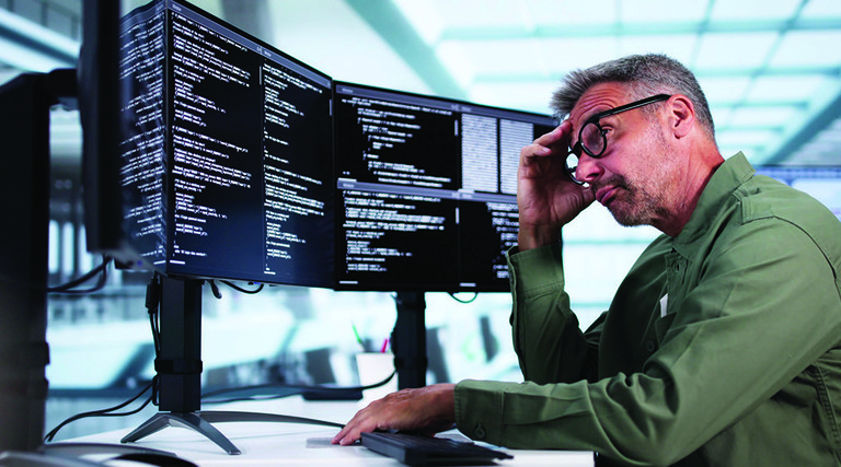 Man looking at coding on computer