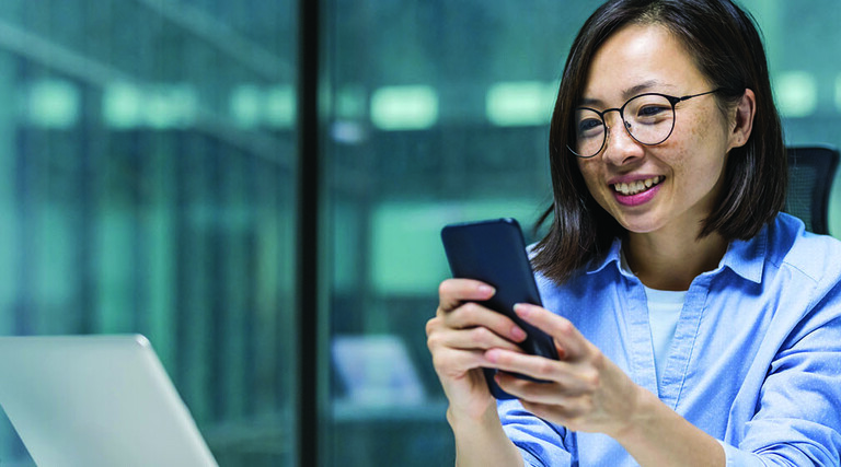 Person using smartphone at desk