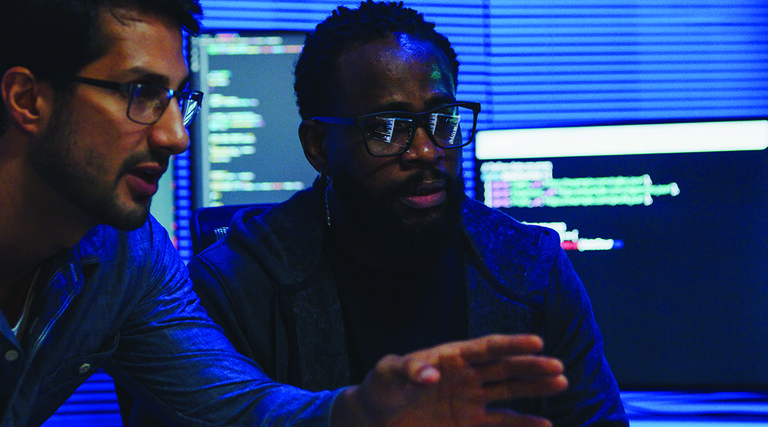 two male coworkers working in tech office