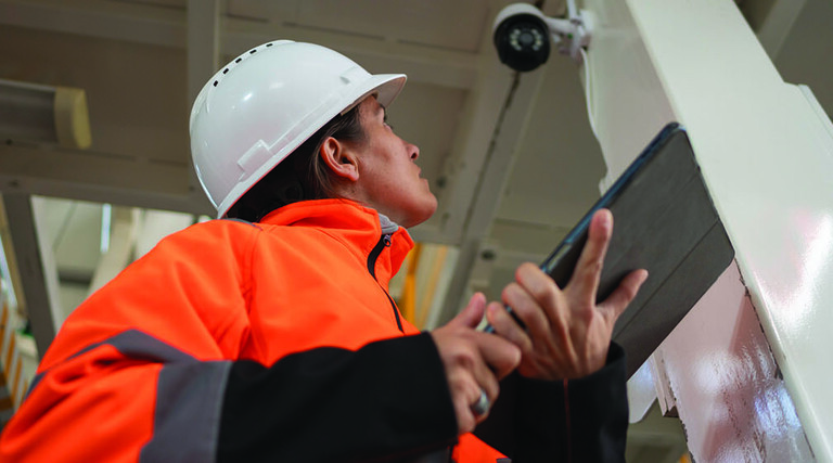 Factory worker inspecting camera