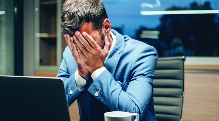 Employee with head in hands
