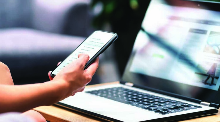 Person using phone and laptop