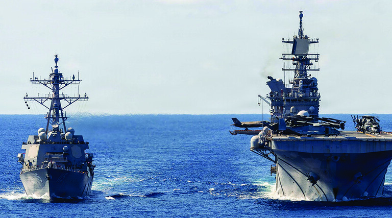 The USS Rafael Peralta (left) steams alongside the USS Tripoli